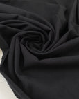 Very soft and warm-touch stretch cotton in black. Lightweight and solid color. High-quality deadstock collected in Stock from a Maison de Couture in Italy.