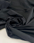 Very light black polyester taffeta with a crisp crunchy texture ideal for structured garments and voluminous shapes. High-quality deadstock collected in Stock from a Maison de Couture in Italy.