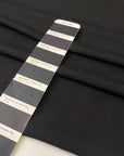 Black polyester crêpe with a fluid drape and slightly textured matte surface ideal for dresses trousers and soft tailoring. High-quality deadstock collected in Stock from a Maison de Couture in Italy.