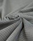 Gray checkered wool and polyester. The fabric is elastic and falling. High-quality deadstock fabric collected in Stock from a Maison de Couture in Italy.