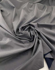 Blue-colored cotton fabric and soft, stretch polyamide membrane with storm system. High quality deadstock fabric.