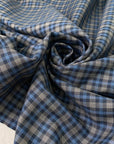 Mixed wool, silk, and cotton with a small check design in the shades of light blue and gray, color reference Blue Jasper. Very soft, medium weight, and flowy. Ideal for trousers, skirts, and jackets. High-quality deadstock collected in Stock from a Maison de Couture in Italy.