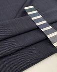 Light wool mixed with polyester with a small checker pattern in dark blue. High-quality deadstock fabric collected in Stock from a Maison de Couture in Italy.
