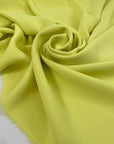 Polyester cady in bright yellow, color reference Sunny Lime. Very soft, light, and flowy, not transparent. Ideal for trousers, dresses, and skirts. High-quality deadstock collected in Stock from a Maison de Couture in Italy.