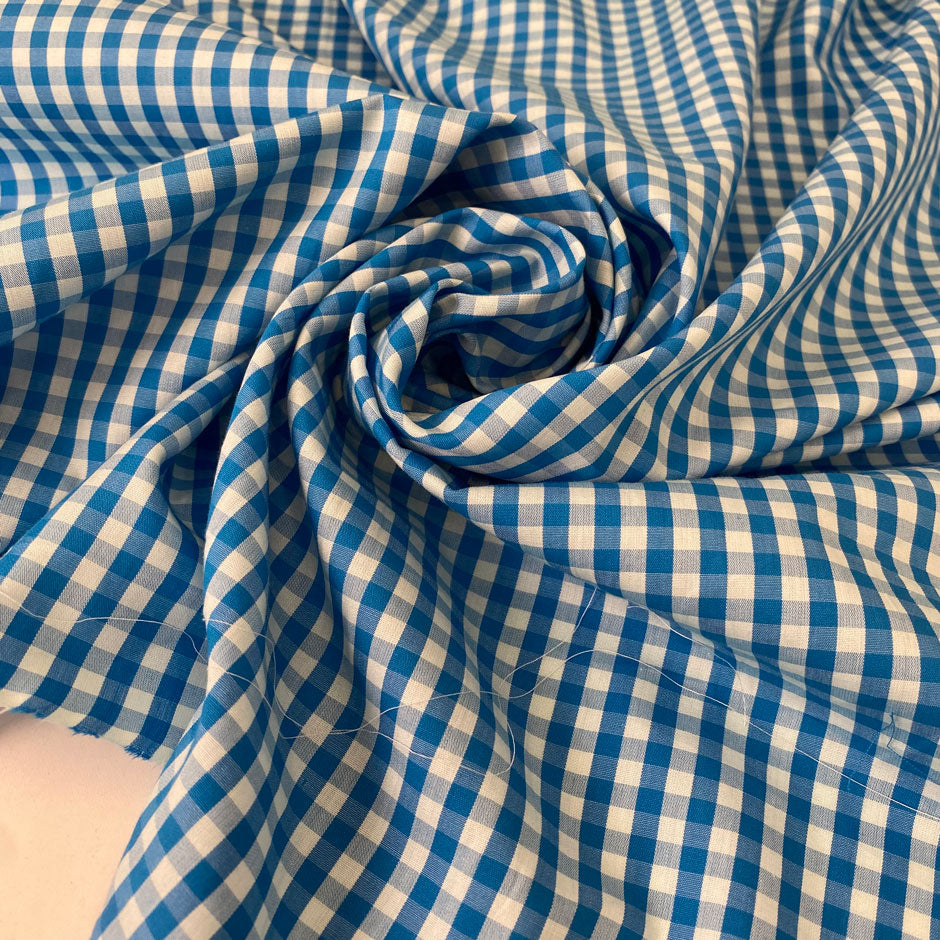 Pure cotton poplin in blue with a small check design (square size approx. half a centimeter). Very soft, light, and not transparent—ideal for shirts, dresses, and skirts. High-quality deadstock collected in Stock from a Maison de Couture in Italy.