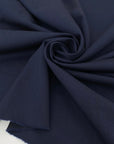 Mixed wool and linen stretch gabardine in dark blue color reference Outer Space. Very soft and flowy, ideal for trousers, skirts, jackets, and dresses. High-quality deadstock collected in Stock from a Maison de Couture in Italy.
