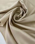 Polyester satin in cream color. Very soft, light, and flowy. Not transparent. Ideal for dresses, skirts, blouses, and shirting. High-quality deadstock collected in Stock from a Maison de Couture in Italy.