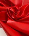 Vinyl fabric in flame red, very stiff in cotton and polyester. High-quality deadstock fabric by the meter collected in Stock from a Maison de Couture in Italy.