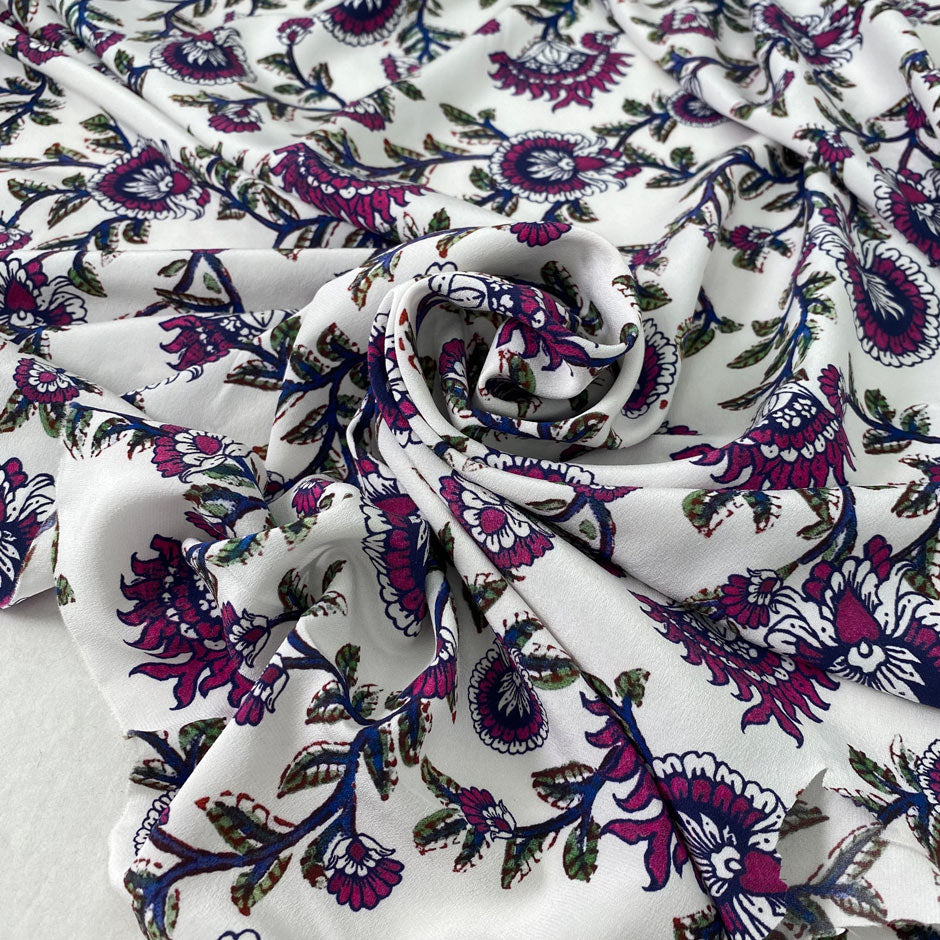 Pure silk crêpe de chine with a white ground and floral design in the shades of festival fuchsia, blue, and green. Very soft and flowy, not transparent. Ideal for dresses, skirts, blouses, and shirting. High-quality deadstock collected in Stock from a Maison de Couture in Italy.