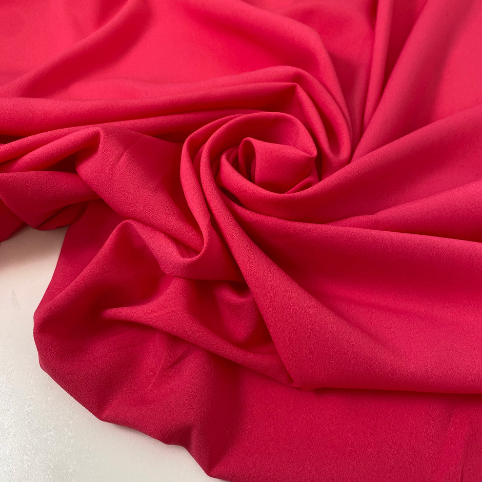 Fluorescent fuchsia polyester crêpe de chine with a fluid drape and matte texture ideal for bold blouses dresses and linings. High-quality deadstock collected in Stock from a Maison de Couture in Italy.