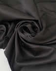 Brown matte polyester satin with a soft touch and elegant drape ideal for dresses skirts and linings. High-quality deadstock collected in Stock from a Maison de Couture in Italy.