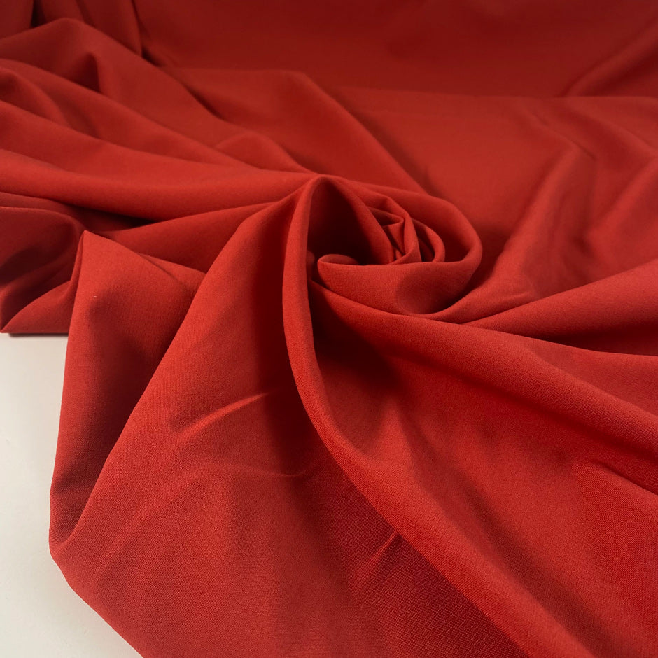 Rusted polyester, viscose, and elastane stretch fabric in paprika orange. Very soft and flowy, medium weight, and not transparent. High-quality deadstock collected in Stock from a Maison de Couture in Italy.