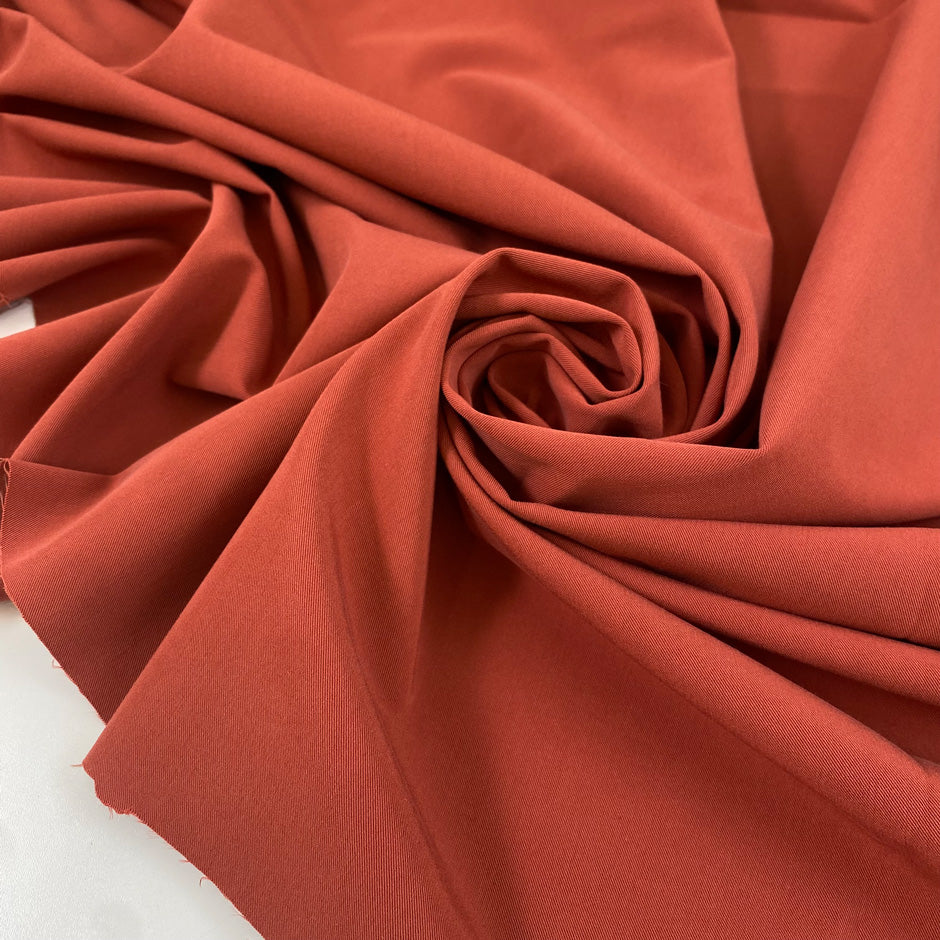 Stretch viscose, polyester, and polyamide comfort in rust color, color reference paprika. Very soft, stretch, and light. Ideal for trousers, dresses, and skirts. High-quality deadstock collected in Stock from a Maison de Couture in Italy.