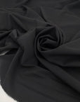 Very soft and flowing polyester georgette in a dark gray shade, color reference Meteorite. Ideal for dresses, skirts, blouses, and shirting. High-quality deadstock collected in Stock from a Maison de Couture in Italy.
