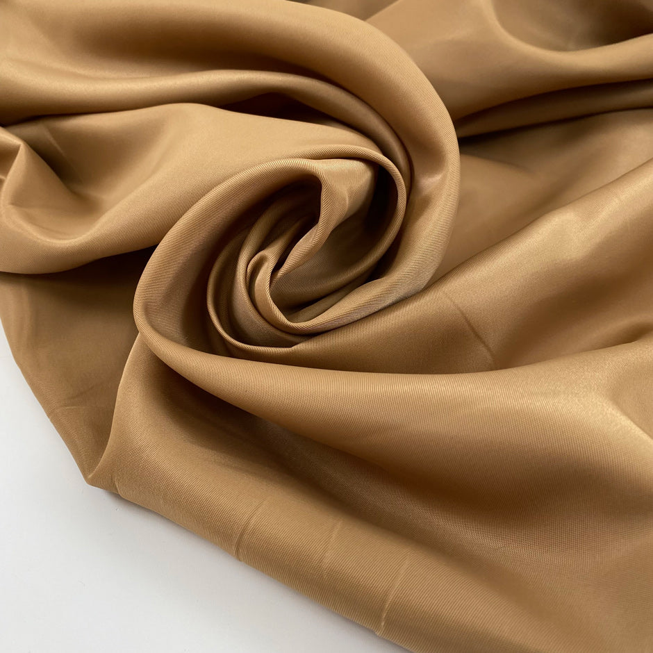 Nylon in camel color with gabardine texture, a little shiny and stiff. High-quality deadstock fabric by the meter collected in Stock from a Maison de Couture in Italy.