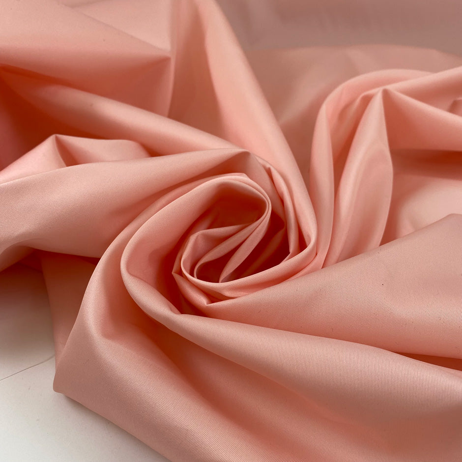 Gabardine nylon peach a little bit shiny and stiff. High-quality deadstock fabric collected in Stock from a Maison de Couture in Italy.