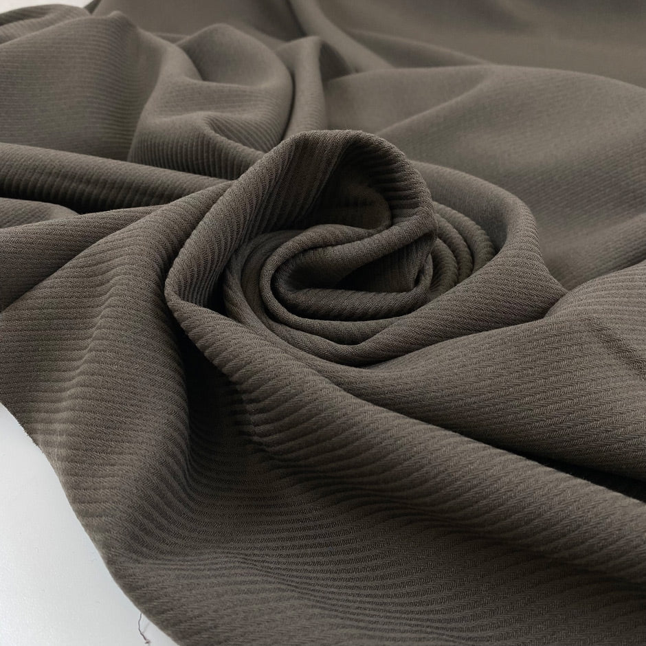 Heavy cotton and viscose with a little elastane in dark gray with striped texture, very flowy, medium weight and not transparent. High-quality deadstock fabric by the meter collected in Stock from a Maison de Couture in Italy.