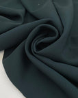 Pure wool in dark forest green with texture. A little bit stiff but flowy and medium weight. Ideal for jackets, skirts, trousers, and light coats. High-quality deadstock collected in Stock from a Maison de Couture in Italy.