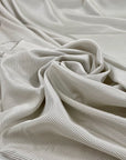 Pure silk crepe de chine with an ivory ground and gray stripes. Very soft and flowy, not transparent. Ideal for dresses, blouses, skirts, and shirting. High-quality deadstock collected in Stock from a Maison de Couture in Italy.
