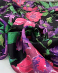 Polyester twill with beautiful flower design. The ground is black and the shades of the flowers are violet, hot pink an,d green. Very soft, light, and flowy. High-quality deadstock fabric by the meter collected in Stock from a Maison de Couture in Italy.