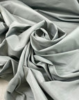Cotton and polyester taffeta in Mirage Gray with a textured finish. Slightly stiff and shape-retaining, ideal for jackets, skirts, and dresses. High-quality deadstock collected in Stock from a Maison de Couture in Italy.