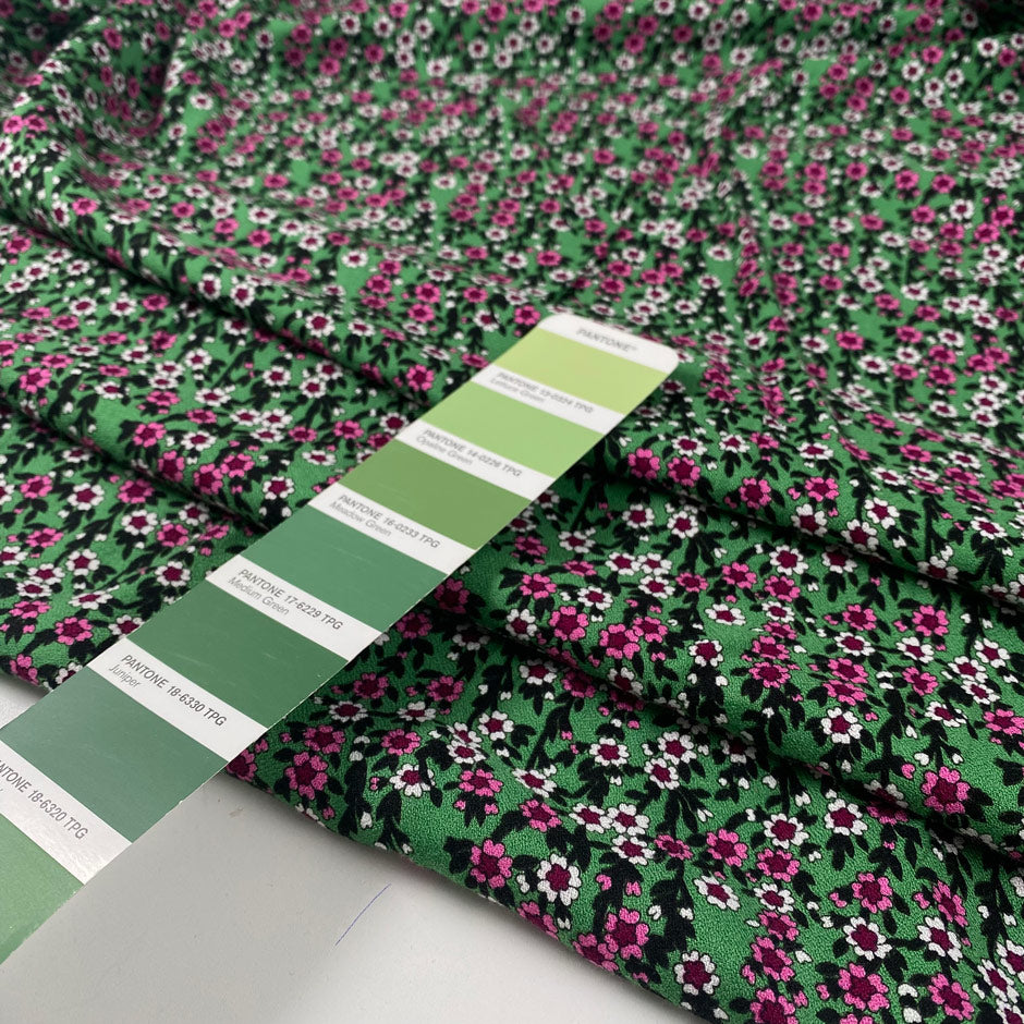 Viscose and wool crepe with a beautiful small flower design, the ground is green and the flowers are in white, fuchsia, and black shades. It is very soft and light. High-quality deadstock fabric by the meter collected in Stock from a Maison de Couture in Italy.
