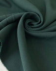 Soft and flowing wool and viscose stretch double crêpe in dark green. Perfect for jackets, skirts, and dresses.High-quality deadstock collected in Stock from a Maison de Couture in Italy.