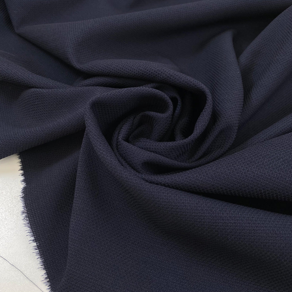 Wool and cotton blend in dark blue with a textured surface. Very soft and light, not transparent. Ideal for dresses, skirts, jackets, and light trousers. High-quality deadstock collected in Stock from a Maison de Couture in Italy.