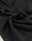 Black polyester jersey soft breathable versatile fabric ideal for everyday garments and activewear. High-quality deadstock collected in Stock from a Maison de Couture in Italy.
