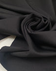 Stretch jersey piquet in polyester and elastane, black color reference Tap Shoe. Very soft, flowy, medium weight and not transparent. Ideal for trousers, dresses, skirts, and jackets. High-quality deadstock collected in Stock from a Maison de Couture in Italy.