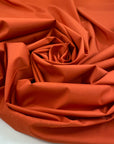 Light and soft waterproof polyester cinzato with elastane in orange, ideal for windbreakers, trenches, and light outerwear. High-quality deadstock collected in Stock from a Maison de Couture in Italy. 