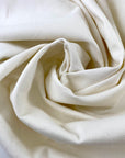 Stretch cotton gabardine in neutral white. Structured and solid. High-quality deadstock collected in Stock from a Maison de Couture in Italy.