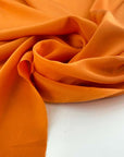 Flowing and falling orange silk crepe de chine fabric. High quality deadstock fabric picked up in Stock from a Maison de Couture in Italy.