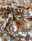 Pure viscose with a lurex stripe. The ground is white with a cashmere design in orange, light blue, and red shades. It is very soft and flowy. Ideal for dresses, blouses, shirts, and skirts. High-quality deadstock fabric by the meter collected in Stock from a Maison de Couture in Italy.