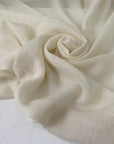 Pure wool muslin in light vanilla color reference Winter White. Very soft, light, and warm, with slight transparency. Flowy and ideal for scarves, light shirting, and dresses. High-quality deadstock collected in Stock from a Maison de Couture in Italy.