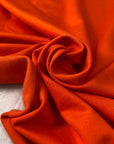 Orange cotton and viscose technical piquet jersey in cherry tomato shade soft stretchy and fluid. Ideal for sweatshirts, trousers, skirts and jackets. High-quality deadstock collected in Stock from a Maison de Couture in Italy.