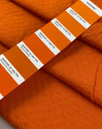 Pure cotton jacquard in vibrant orange, color reference Shakar. Very soft, flowy, and not transparent. Ideal for jackets, dresses, trousers, and skirts. High-quality deadstock collected in Stock from a Maison de Couture in Italy.