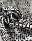 Polyester and elastane satin with small geometric design in shades of grey, white, and black, very soft, light, flowy, not transparent, with a shiny effect. High-quality deadstock collected in Stock from a Maison de Couture in Italy.