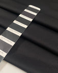 Stretch jersey piquet in polyester and elastane, black color reference Tap Shoe. Very soft, flowy, medium weight and not transparent. Ideal for trousers, dresses, skirts, and jackets. High-quality deadstock collected in Stock from a Maison de Couture in Italy.