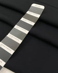 Polyester cady in black color reference Pirate Black. Very soft and flowy, not transparent, ideal for trousers, skirts, and dresses. High-quality deadstock collected in Stock from a Maison de Couture in Italy.