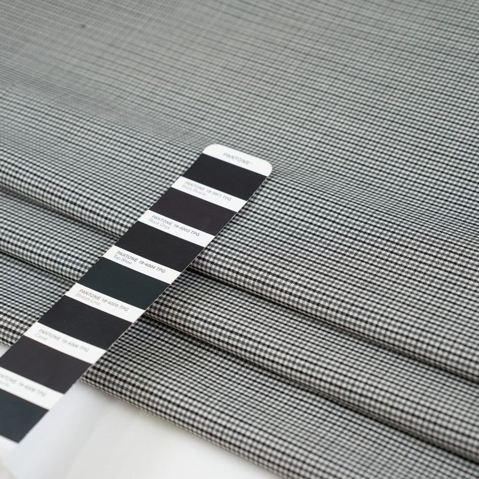 Gray checkered wool and polyester. The fabric is elastic and falling. High-quality deadstock fabric collected in Stock from a Maison de Couture in Italy.
