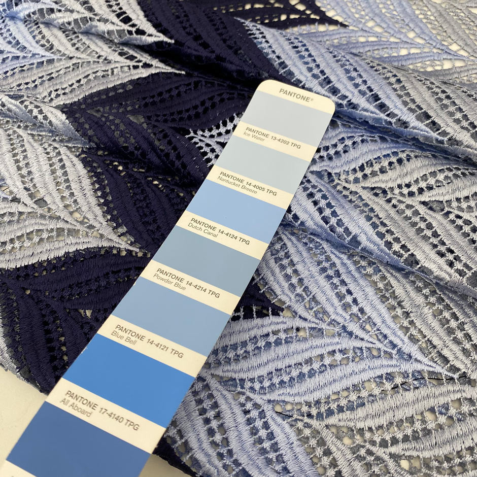Polyester macramé lace with geometric pattern in light blue, gray, and dark blue. Light, detailed, and double scalloped. Ideal for dresses, skirts, shirting, or blouses. High-quality deadstock collected in Stock from a Maison de Couture in Italy.
