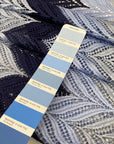 Polyester macramé lace with geometric pattern in light blue, gray, and dark blue. Light, detailed, and double scalloped. Ideal for dresses, skirts, shirting, or blouses. High-quality deadstock collected in Stock from a Maison de Couture in Italy.