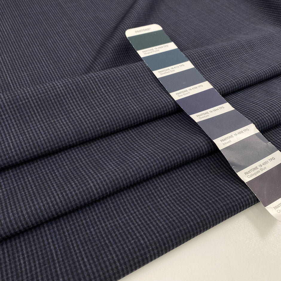 Light wool mixed with polyester with a small checker pattern in dark blue. High-quality deadstock fabric collected in Stock from a Maison de Couture in Italy.