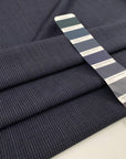 Light wool mixed with polyester with a small checker pattern in dark blue. High-quality deadstock fabric collected in Stock from a Maison de Couture in Italy.