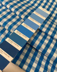 Pure cotton poplin with a small check design, approximately one centimeter squares, in light blue color reference Bu Blue. Very soft, light, flowy, and not transparent. Ideal for shirting, dresses, and skirts. High-quality deadstock collected in Stock from a Maison de Couture in Italy.