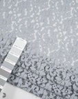 Gray cotton and polyester rebrodè lace fabric. It is falling and transparent. High-quality deadstock fabric collected in Stock from a Maison de Couture in Italy.