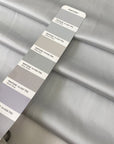 Polyester satin in light gray, Glacier Gray. Very soft, light, shiny and flowy, not transparent. Ideal for dresses, skirts, blouses, and shirting. High-quality deadstock collected in Stock from a Maison de Couture in Italy.