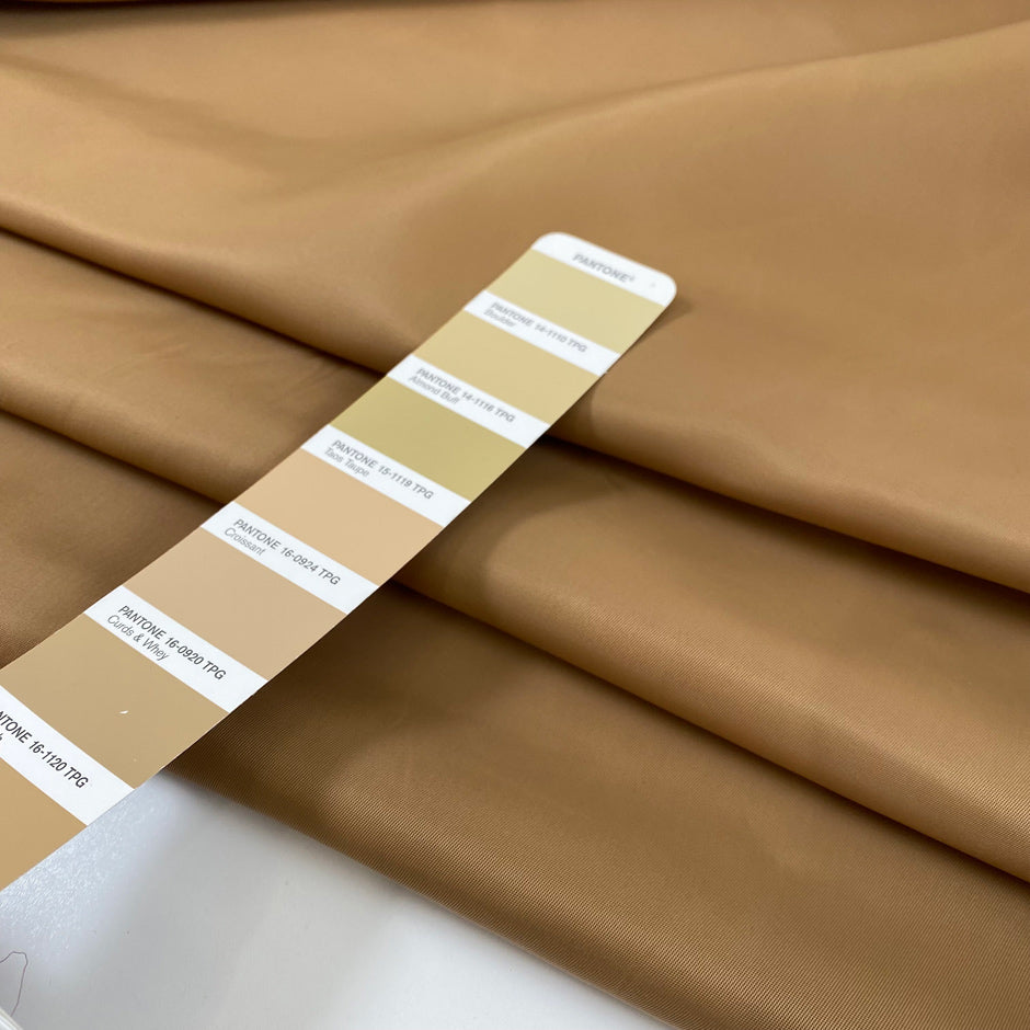 Nylon in camel color with gabardine texture, a little shiny and stiff. High-quality deadstock fabric by the meter collected in Stock from a Maison de Couture in Italy.