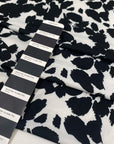 Printed polyester jersey with black spots on a white base soft and fluid ideal for tops dresses and layering pieces. High-quality deadstock collected in Stock from a Maison de Couture in Italy.